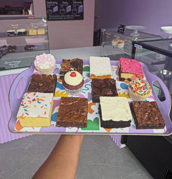 A tray of freshly cut traybakes, brownies and blondies among them